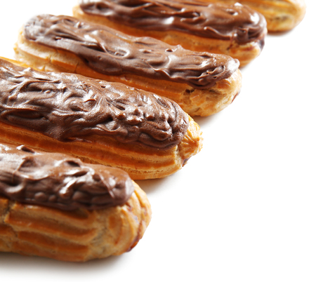 Delicious chocolate eclairs in row on white background, closeupの写真素材