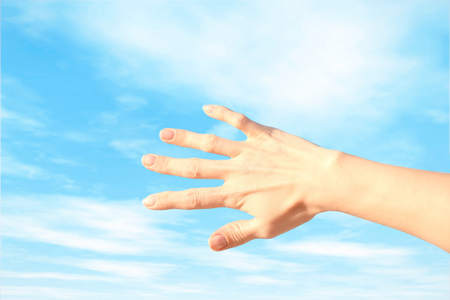 Female hand on sky backgroundの写真素材