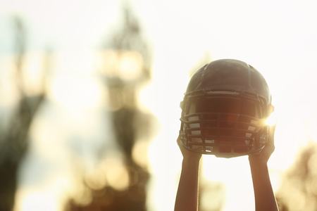 Male hands holding rugby helmetの写真素材