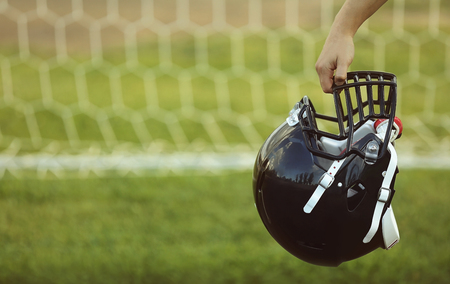 Male hand holding rugby helmetの写真素材