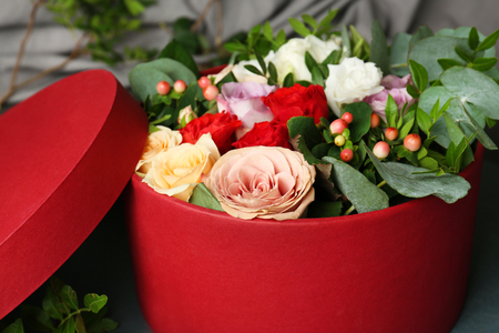 Floral arrangement in box on grey fabric closeup
