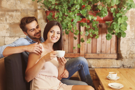 Beautiful young couple drinking coffee on dateの写真素材