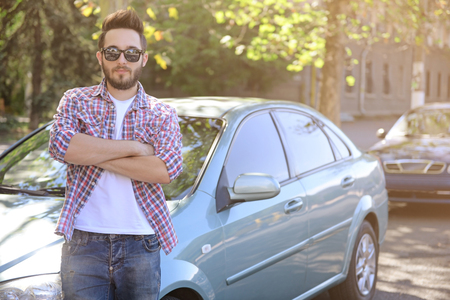 Successful young man standing near carの写真素材