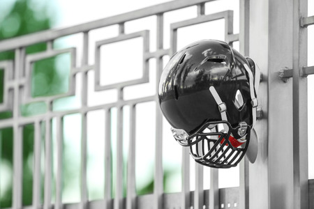 Rugby helmet on metal fenceの写真素材