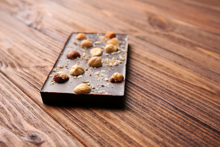 Chocolate bar with nuts on wooden tableの写真素材