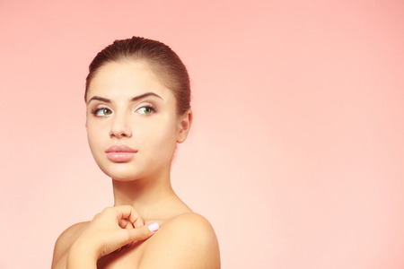 Portrait of beautiful young woman on color backgroundの写真素材