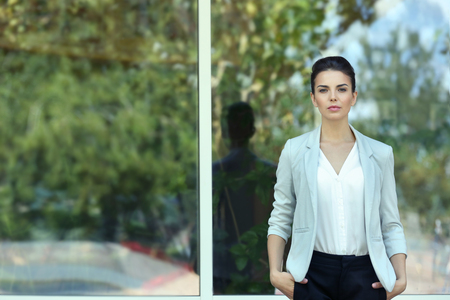 Beautiful businesswoman on window backgroundの写真素材