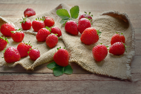 Fresh strawberries on bagging and wooden backgroundの写真素材