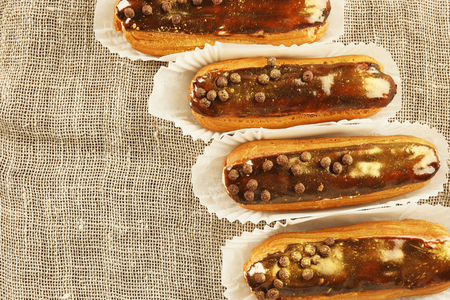 Delicious eclairs on sackcloth background