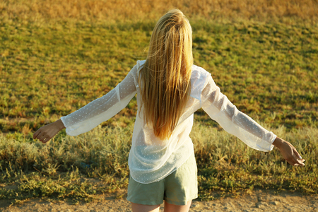 Young woman walking on field backgroundの写真素材