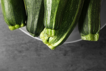 Bowl with fresh green zucchini on color backgroundの写真素材