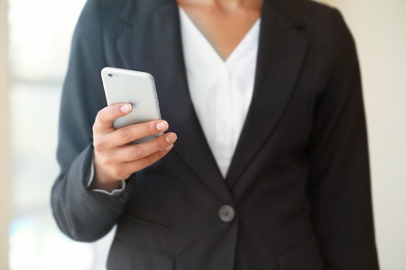 Businesswoman with cellphone in officeの写真素材