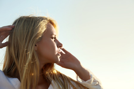 Happy young woman on sky backgroundの写真素材