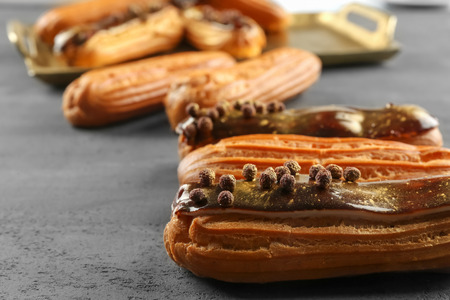 Delicious eclairs on grey textured background