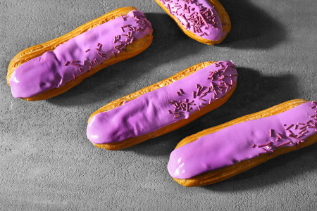 Delicious glazed eclairs on dark textured backgroundの写真素材
