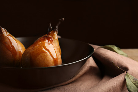Baked pears in plate on black backgroundの写真素材