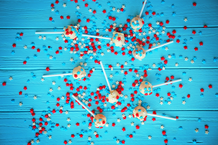Delicious lollipops and scattered sprinkles on blue wooden backgroundの写真素材