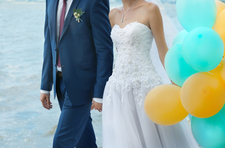 Newlyweds with balloons near riverの写真素材