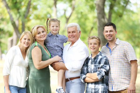 Large happy family resting in sunny parkの写真素材