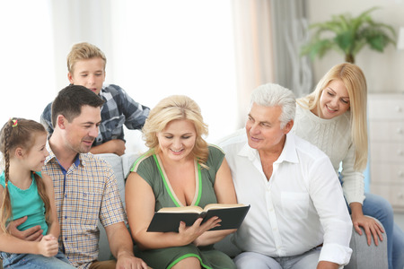 Happy family reading book at home