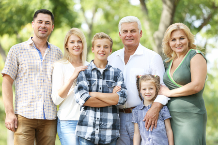 Large happy family resting in sunny parkの写真素材