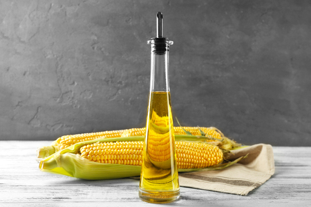Corn and oil in bottle on grey background, closeupの写真素材