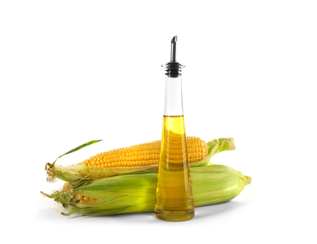Fresh corn with bottle of oil on white backgroundの写真素材