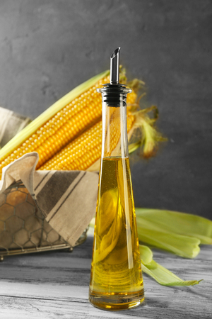 Corn and oil in bottle on grey background, closeupの写真素材
