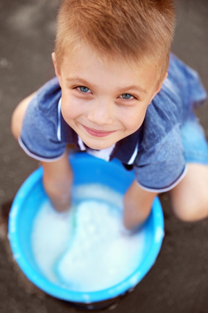 Cute boy with bucket and sponge, closeupの写真素材