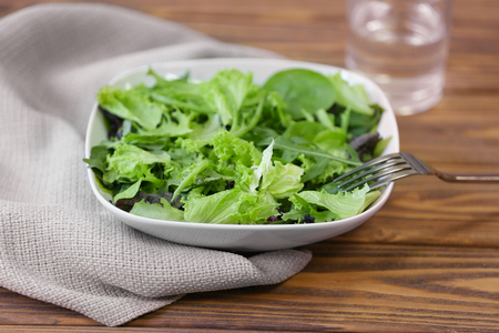 Fresh delicious salad on wooden background, closeupの写真素材