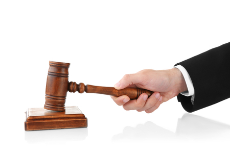 Judge's hand holding gavel on white backgroundの写真素材