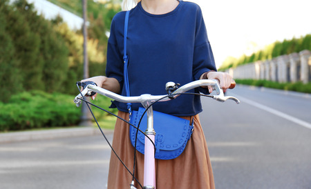 Young woman riding bicycle along roadの写真素材