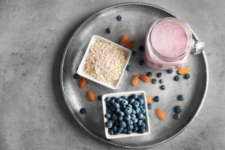 Mason jar with tasty smoothie and some ingredients on kitchen tableの写真素材
