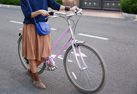 Young woman with bicycle on roadの写真素材
