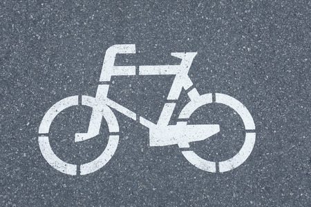 Bicycle sign on grey asphalt pavement, close up viewの写真素材