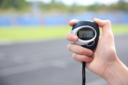 Female hand holding digital stopwatch, close up