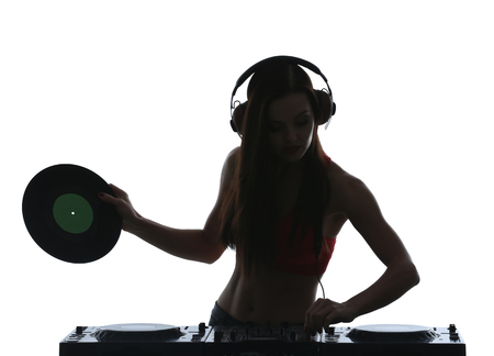 Portrait of pretty young DJ playing music on light backgroundの写真素材