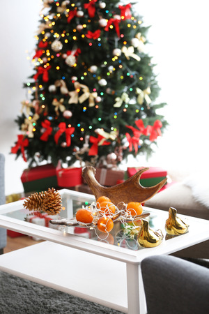 Mandarins and cones on table in decorated roomの写真素材
