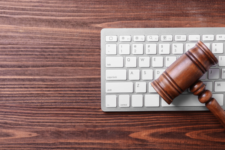 Wooden gavel and keyboard on desk