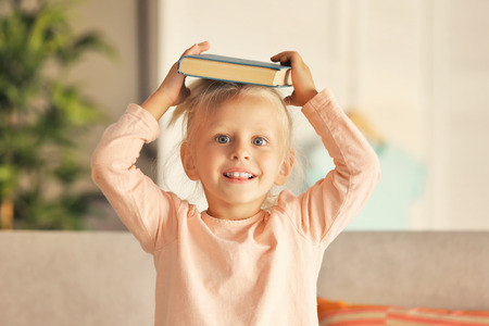 Small girl plying with book at homeの写真素材