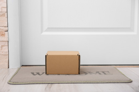 Cardboard box on rug under entrance doorの写真素材