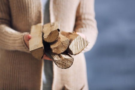 Woman holding pile of firewood, close up viewの写真素材