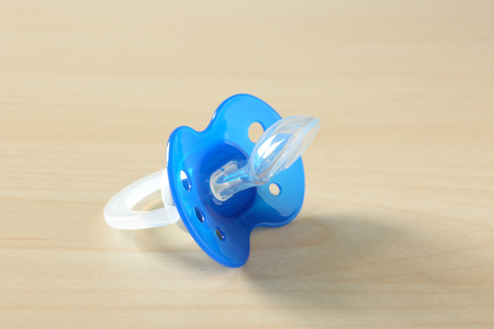 Baby pacifier on wooden background
