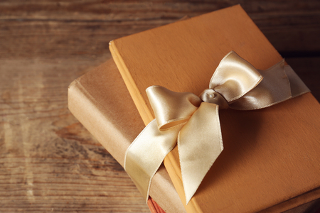 Old books tied in ribbon on wooden background, closeupの写真素材