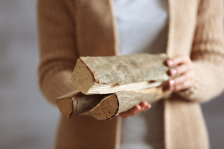 Woman holding pile of firewood, close up viewの写真素材