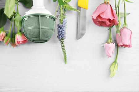 Beautiful flowers and florist equipment on wooden backgroundの写真素材