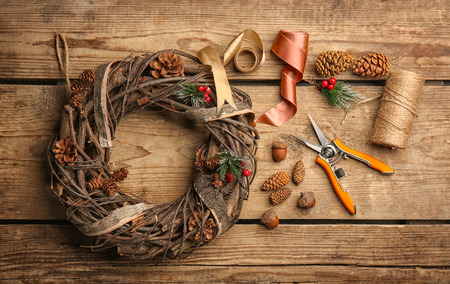Decorative wreath and florist equipment on wooden backgroundの写真素材