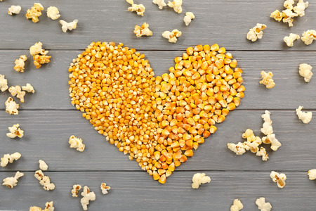 Heart made of maize grains on wooden background, top viewの写真素材