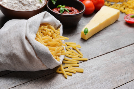 Dry pasta in sack on wooden backgroundの写真素材