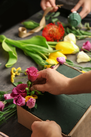 Female hands making beautiful flower composition in floral shopの写真素材